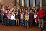 Gruppenbild mit den Kindern und allen Helferinnen neben dem Eingang zur Kirche