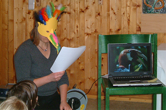 Ein "Paradiesvogel" aus dem Kindergottesdienstteam beim Zeigen von Fotos aus Papua-Neuguinea