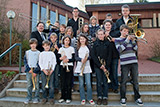 Die Jungblserinnen und Jungblser der Brass Kids mit ihrem Leiter Karl Reissig auf den Stufen vor der Trinitatiskirche.