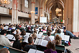 Blick in Richtung Altarraum der Lutherischen Pfarrkirche in Marburg. In den Bnken sitzen die Jungblserinnen und Jungblser mit ihren Instrumenten.