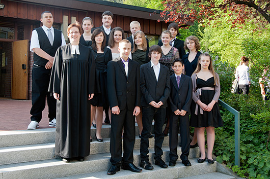 Die Konfirmanden 2011 und Pfarrerin Bettina Mohr vor dem Eingang zur Trinitatiskirche