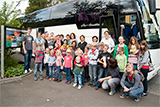 Alle Kinder, Eltern, Helferinnen und Helfer vor dem abfahrbereiten Bus.