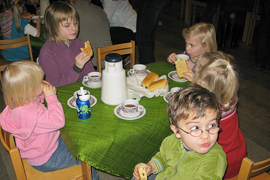 Bei Tee und Gebck lassen es sich die Kinder am Tisch schmecken.