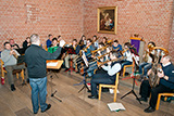 Der Posaunenchor mit Dirigent Marc Multhaupt beim Einspielen im Kirchraum der Trinitatiskirche.