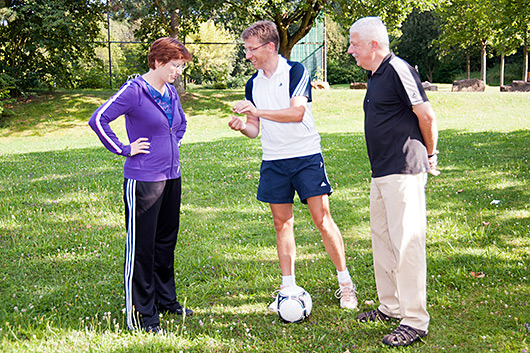 Pfarrerin Bettina Mohr, Heinz Rau und Joachim Striepecke bei der Auslosung des Tippspiel-Gewinners auf der Rasenflche neben der Kirche.