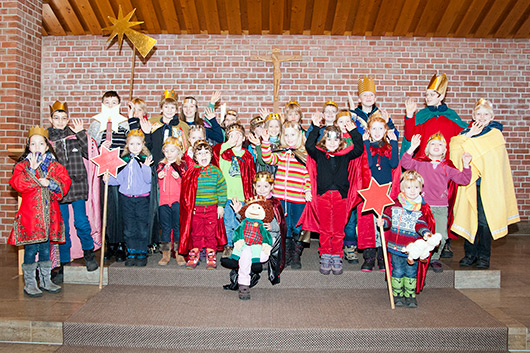 Alle 26 Sternsinger stehen vor dem Altar der Trinitatiskirche und winken in die Kamera.