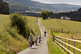 Blick von der Weinstrae auf den steilen Anstieg, auf dem einige Radfahrerinnen und Radfahrer zu sehen sind.