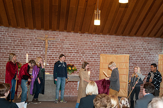 Blick in den Altarraum der Trinitatiskirche, wo die Konfirmandinnen und Konfirmanden in einem Anspiel zum Martinstag zu sehen sind.