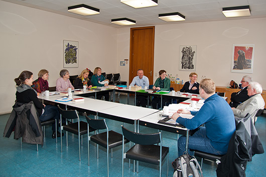 Die Kirchenvorsteherinnen und Kirchenvorsteher sitzen diskutierend an Tischen im Besprechungsraum des Gemeindehauses der Matthuskirche.