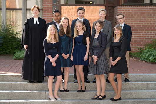 Die Konfirmandinnen und Konfirmanden haben sich vor dem Konfirmationsgottesdienst zum Gruppenbild vor der Kirche aufgestellt.