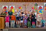 Die Kinder- und Teeny-Gottesdienstkinder beim Singen und Hpfen im Altarraum.