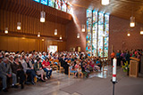 Blick auf die Gemeinde im Kirchraum und den Gospelchor der Martinskirche, der sich im linken Bereich des Altarraums zum Singen aufgestellt hat.