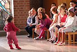 Einige Schulanfngerinnen und Schulanfnger beobachten gebannt ein kleines Kind, das im Altarraum der Trinitatiskirche luft.