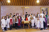 Die Kinder und Jugendlichen, die am Krippenspiel mitwirkten, haben sich zum Gruppenbild vor dem Altar aufgestellt.