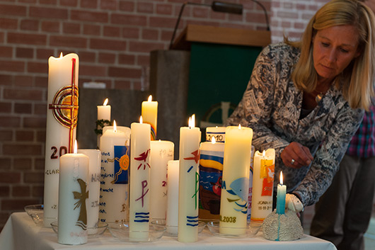 Die Taufkerzen von Kindern, die den Tauferinnerungsgottesdienst besuchten, sind auf einem Tisch im Altarraum der Trinitatiskirche aufgestellt.