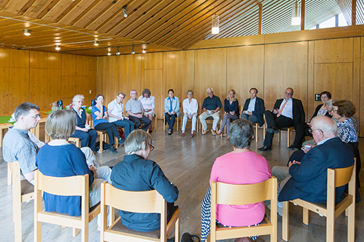 Blick in den groen Gemeinderaum, wo rund 20 Gottesdienstbesucher/innen im Kreis sitzend am Predigtnachgesprch teilnehmen.