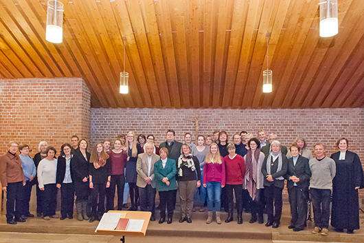 Die teilnehmenden Musikerinnen und Musiker stehen beim Schluss-Applaus im Altarbereich der Kirche.