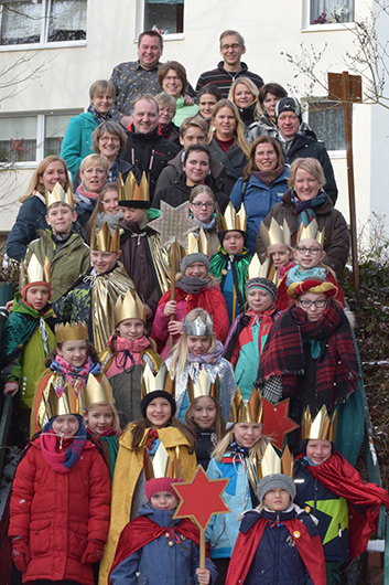 Die Sternsinger haben sich mit ihren Betreuerinnen und Betreuern auf der Treppe neben der Trinitatiskirche zum Gruppenbild aufgestellt.