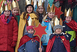 Die Sternsinger haben sich mit ihren Betreuerinnen und Betreuern auf der Treppe neben der Trinitatiskirche zum Gruppenbild aufgestellt.