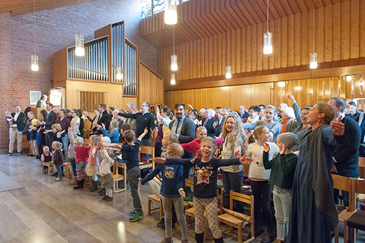 Blick in den Kirchenraum, wo die Besucherinnen und Besucher des Gottesdienstes sich zur Musik bewegen.