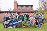 Die Mitwirkenden an der Gartenaktion haben sich auf der Westseite des Gemeindezentrums zum Gruppenbild aufgestellt.