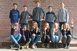 Die elf Konfirmandinnen und Konfirmanden des aktuellen Jahrgangs haben sich vor dem Altar zum Gruppenbild aufgestellt.