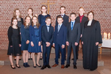 Vor dem Altar stehen die festlich gekleideten Noch-Konfirmandinnen und -konfirmanden und Pfarrerin Mohr.