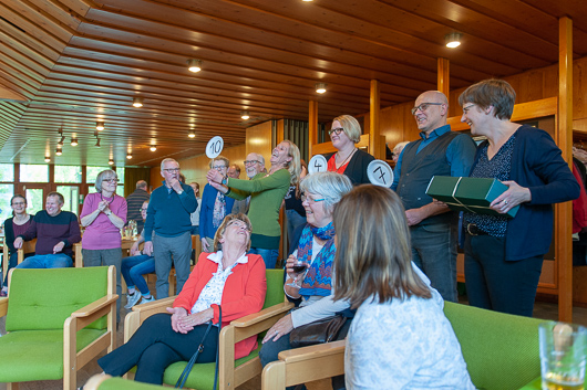 Mitarbeiterinnen und Mitarbeiter der Trinitatiskirche stehen im Halbkreis im Foyer der Kirche und applaudieren.