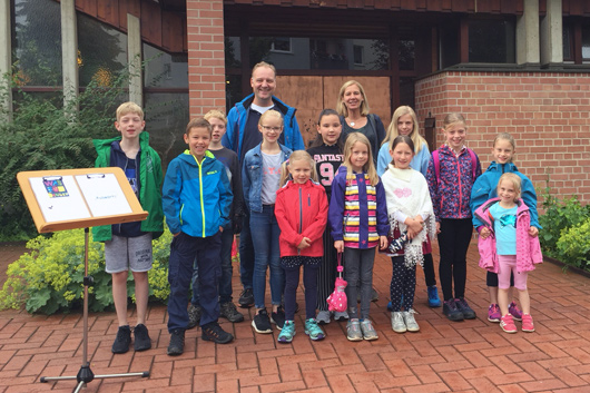 Die Kinder und angehenden Jugendlichen haben sich vor der Kirche zum Gruppenbild aufgestellt.