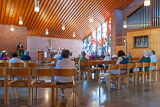 Blick vom Eingang des Kirchenraums in Richtung Altar und Kanzel, wo Pfarrerin Mohr beim Halten der Predigt zu sehen ist.