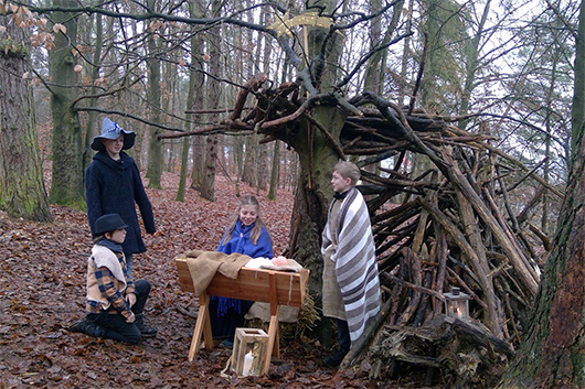 Szenenbild aus dem diesjhrigen Krippenspiel: Vor einem improvisierten Stall im Wald sind der kleine Hirte, der groe Ruber, Maria, Josef und das Jesuskind zu sehen.