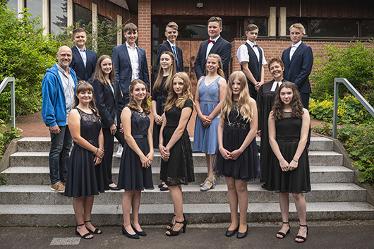 Die vierzehn Konfirmandinnen und Konfirmanden mit Pfarrerin Kirchhoff-Mller und Markus Klonk haben sich zum Gruppenfoto vor der Trinitatiskirche aufgestellt.