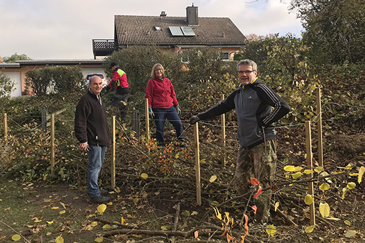 Einige der Teilnehmer*innen an der Gartenaktion beim Aufbau einer sogenannten Benjeshecke.