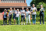 Kinder und 10Plusler bringen beim Gemeindefest die Buchstabenfolge SIND WIR BUNT an einer Leine an.