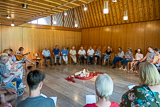 Die Besucherinnen und Besucher des Gottesdienstes sitzen im Kreis und singen.