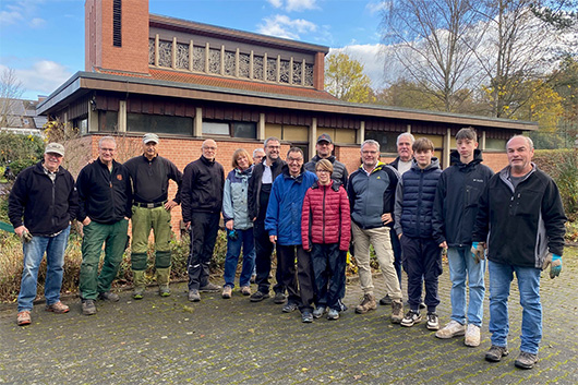 Die Teilnehmerinnen und Teilnehmer an der Gartenaktion haben sich im Auenbereich der Trinitatiskirche zum Gruppenbild aufgestellt.