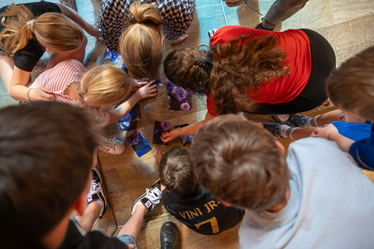 Im Altarraum knien und hocken zahlreiche Mitglieder des Trini-Teams beim Zusammenfgen eines Bild-Puzzles.