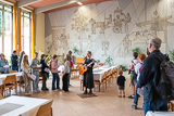 Blick in den Saal der Schwesterngemeinschaft des Diakonissenhauses Hebron, wo Schwester Christina die Teilnehmerinnen und Teilnehmer des Wandergottesdienst mit einem geistlichen Impuls begrüßt.